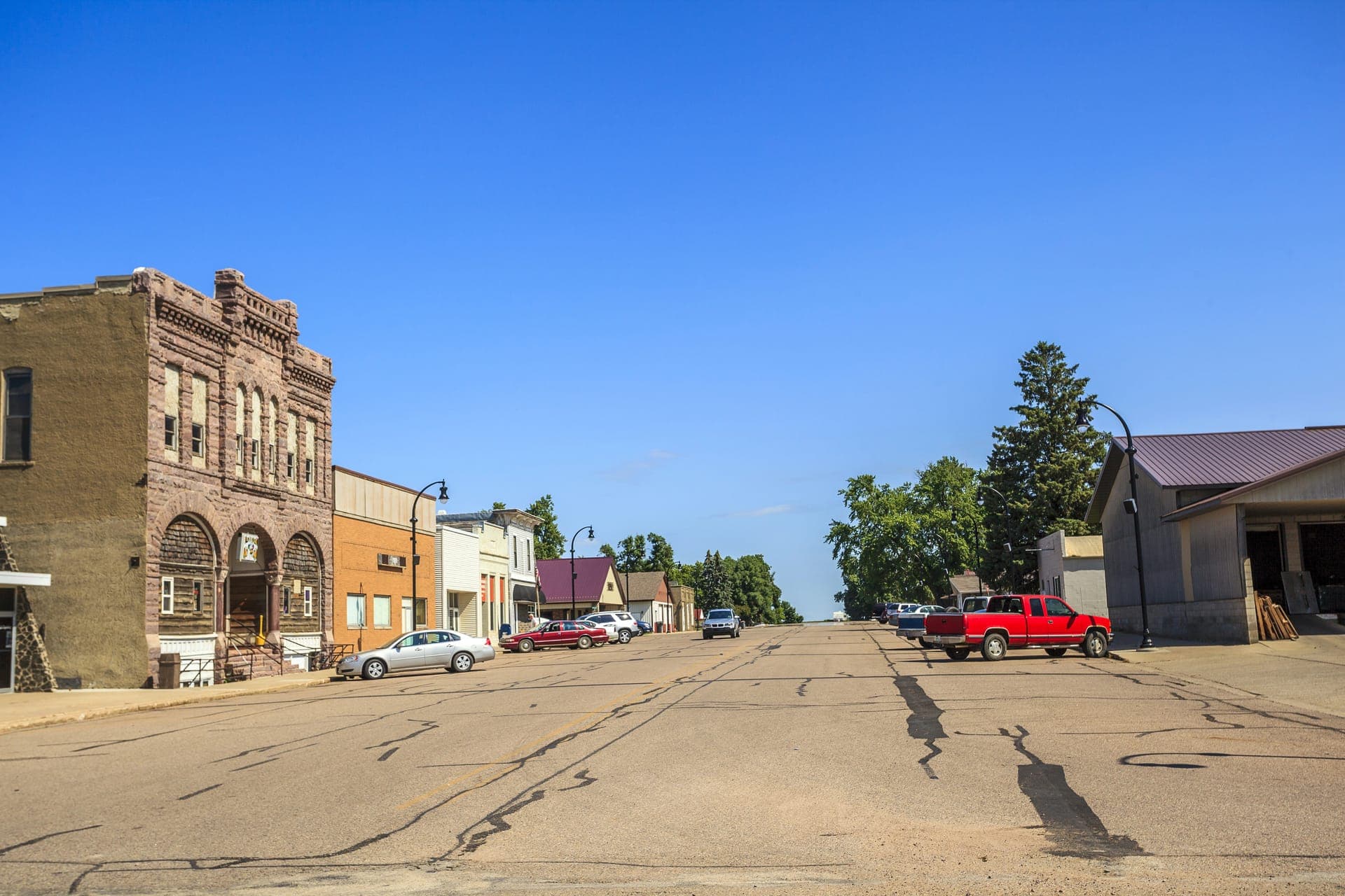 A small town main street in Iowa lined with brick storefronts under a clear sky.